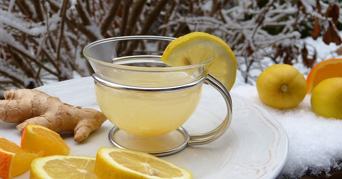 cup of lemon juice surrounded by lemons